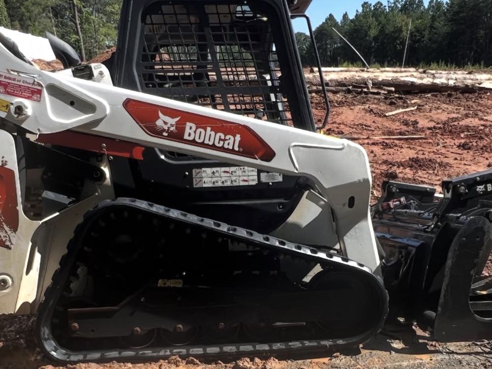After: the same Bobcat T66 washed clean, white body and black tracks