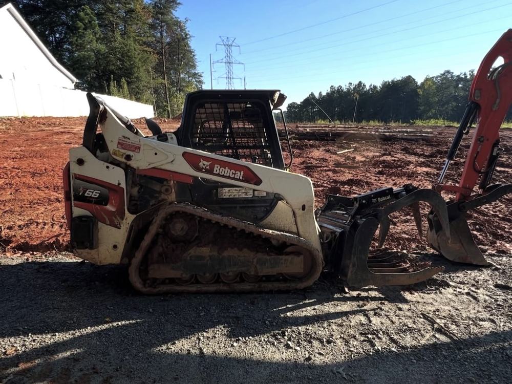 Before: Bobcat T66 compact track loader caked in red clay mud