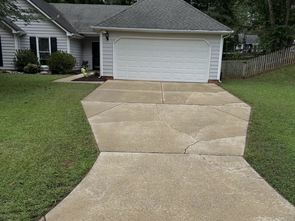 After: the same driveway washed clean and bright, seen from the street