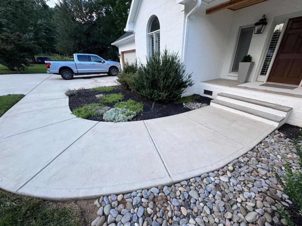 After: clean, bright curved front walkway at the same white brick house