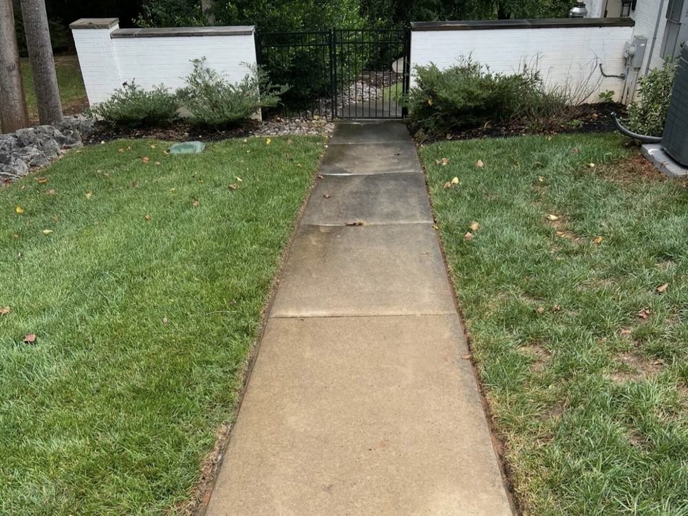 Before: stained, dingy concrete walkway leading to a black iron gate